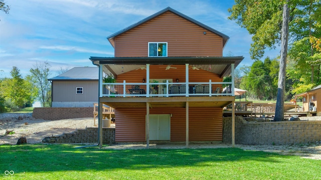 back of house featuring a deck and a lawn