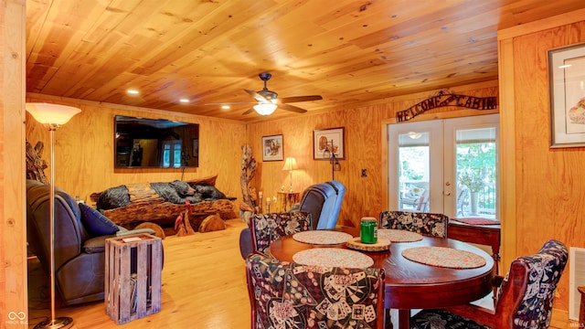 dining room featuring wood ceiling, ceiling fan, wood walls, light hardwood / wood-style floors, and french doors