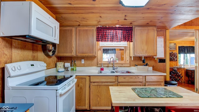 kitchen with white appliances, wood walls, wooden ceiling, and sink