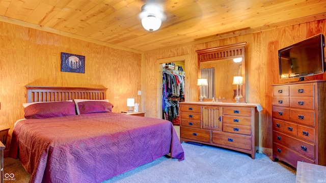 carpeted bedroom featuring a closet, wooden ceiling, a spacious closet, and wooden walls