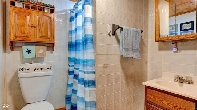 bathroom featuring vanity, toilet, tile walls, and walk in shower