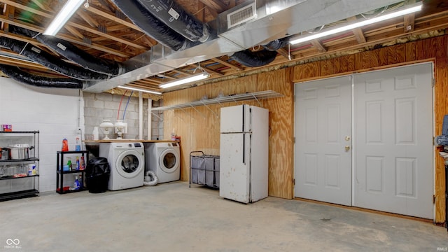 basement featuring white fridge and separate washer and dryer