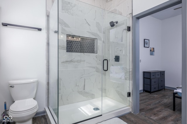 2221 E Michigan St, Indianapolis, IN 46201 - bathroom featuring baseboards, wood finished floors, a shower stall, and toilet
