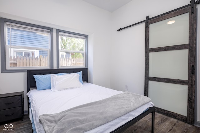 2221 E Michigan St, Indianapolis, IN 46201 - bedroom featuring a barn door and dark wood-type flooring
