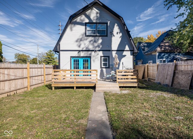 2221 E Michigan St, Indianapolis, IN 46201 - rear view of house with a yard, a gambrel roof, a wooden deck, and a fenced backyard