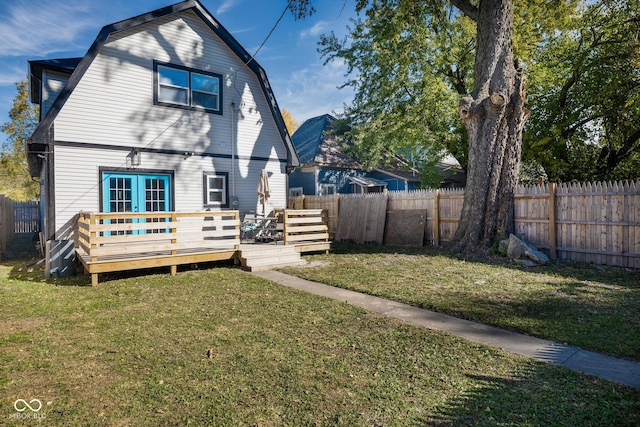 2221 E Michigan St, Indianapolis, IN 46201 - back of property featuring a gambrel roof, a lawn, a wooden deck, and a fenced backyard
