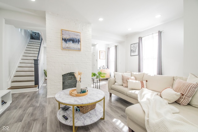 living room featuring hardwood / wood-style flooring and a brick fireplace