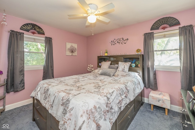 bedroom featuring dark colored carpet, multiple windows, and ceiling fan