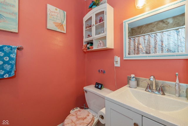 bathroom featuring toilet, a shower with curtain, and vanity