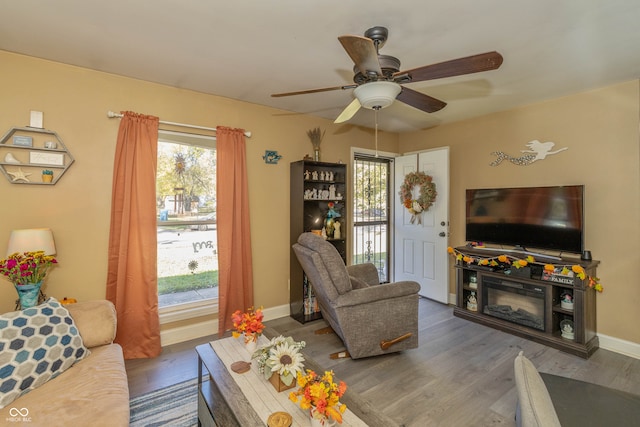 living room with dark hardwood / wood-style floors and ceiling fan