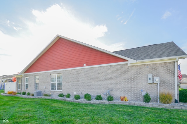 view of side of property featuring a lawn and cooling unit