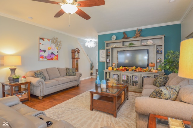 living room featuring hardwood / wood-style floors, ceiling fan with notable chandelier, and crown molding