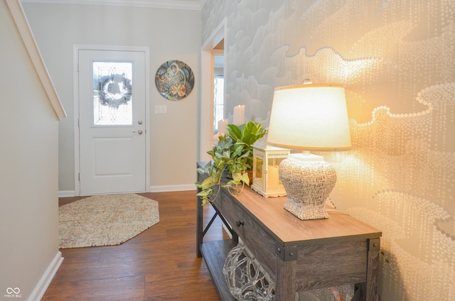 entrance foyer featuring dark wood-type flooring and ornamental molding