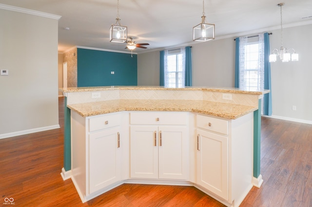 kitchen featuring a kitchen island, hardwood / wood-style floors, pendant lighting, white cabinets, and ceiling fan with notable chandelier