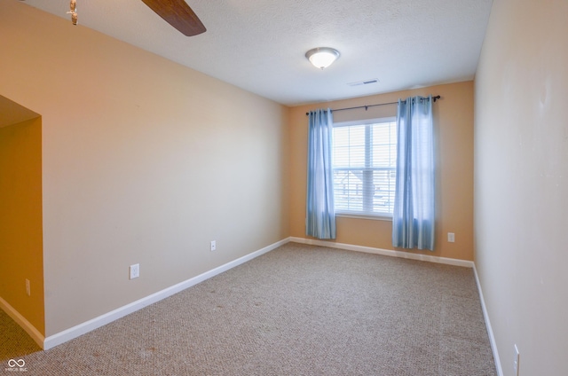 spare room with carpet flooring, ceiling fan, and a textured ceiling