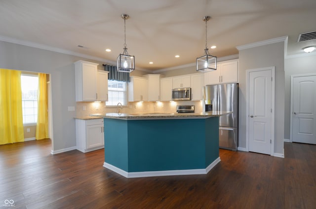 kitchen with appliances with stainless steel finishes, a center island, white cabinetry, and dark hardwood / wood-style flooring