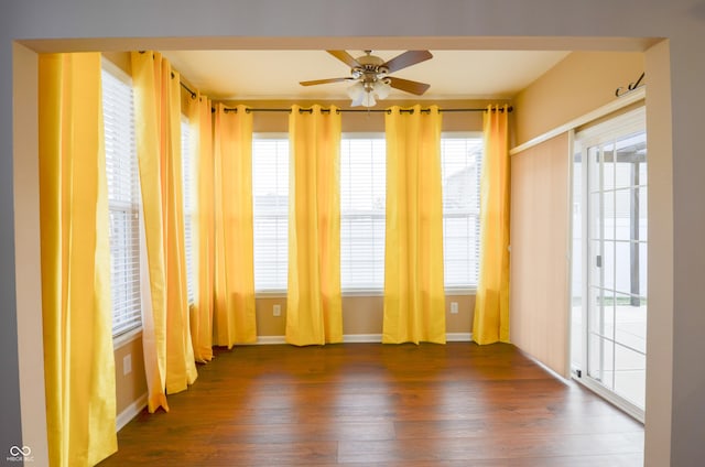 unfurnished room with ceiling fan and dark wood-type flooring