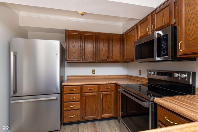 8168 Shorewalk Dr Unit A, Indianapolis, IN 46236 - kitchen featuring light countertops, stainless steel appliances, brown cabinets, and light wood-style flooring