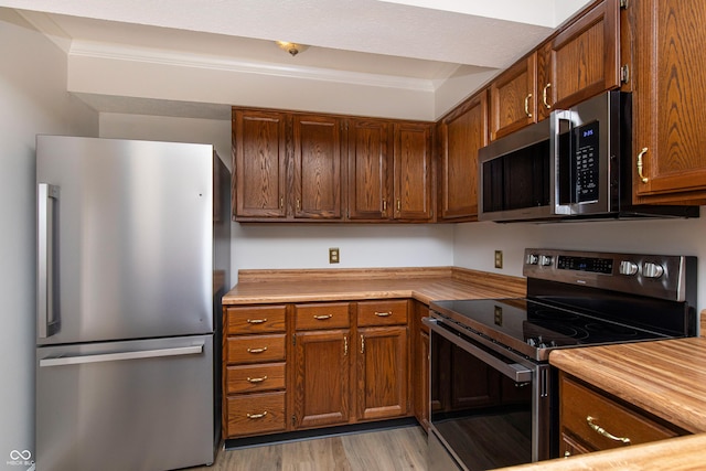 8168 Shorewalk Dr Unit A, Indianapolis, IN 46236 - kitchen featuring light countertops, stainless steel appliances, brown cabinets, and light wood-style flooring