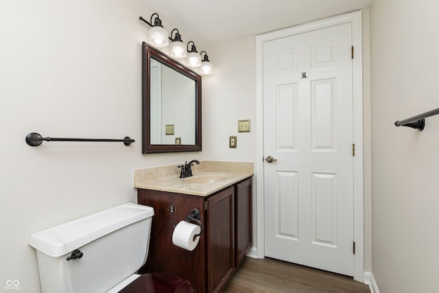 bathroom featuring toilet, hardwood / wood-style floors, vanity, and a textured ceiling