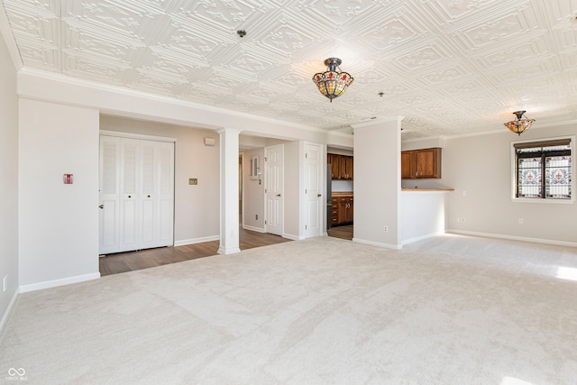 unfurnished living room featuring crown molding, light hardwood / wood-style flooring, and ornate columns