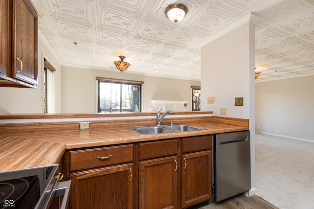 kitchen featuring appliances with stainless steel finishes, sink, kitchen peninsula, light carpet, and crown molding