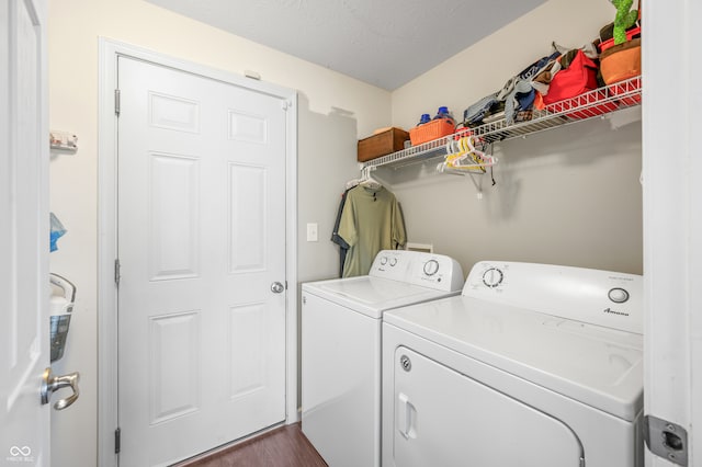 clothes washing area featuring dark wood-type flooring, washer and dryer, and a textured ceiling