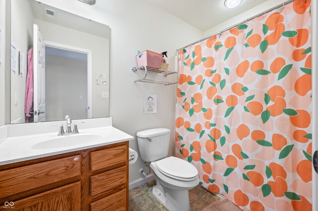 bathroom featuring vanity, walk in shower, and toilet