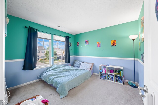 carpeted bedroom with a textured ceiling