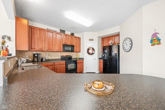 kitchen featuring a textured ceiling, tasteful backsplash, black appliances, and sink