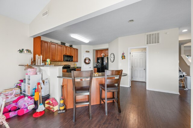 kitchen with black appliances, kitchen peninsula, lofted ceiling, dark wood-type flooring, and a breakfast bar