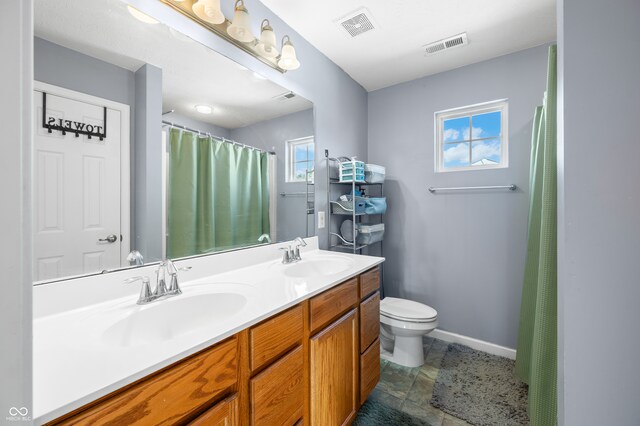 bathroom featuring vanity, toilet, and tile patterned flooring