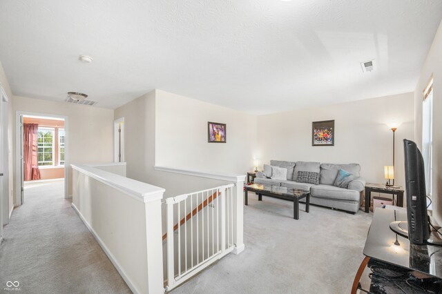 carpeted living room featuring a textured ceiling