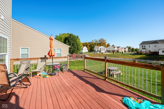 wooden deck featuring a lawn