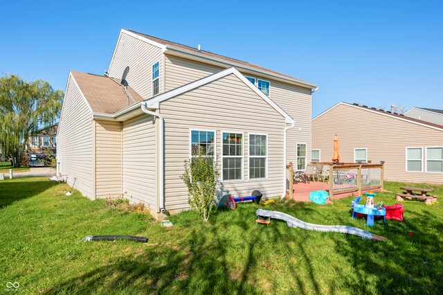 back of house with a patio and a lawn