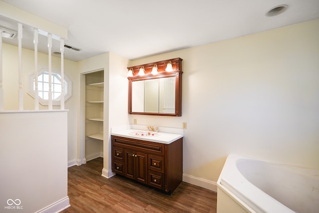 bathroom featuring a bathtub, vanity, and wood-type flooring