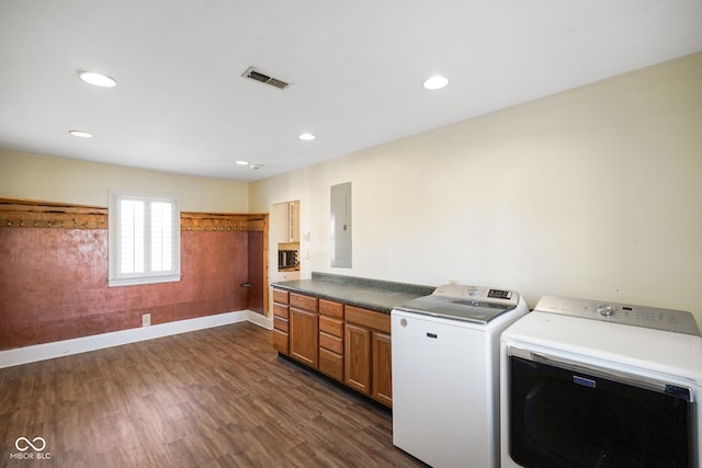 laundry area with cabinets, dark wood-type flooring, electric panel, and washing machine and clothes dryer