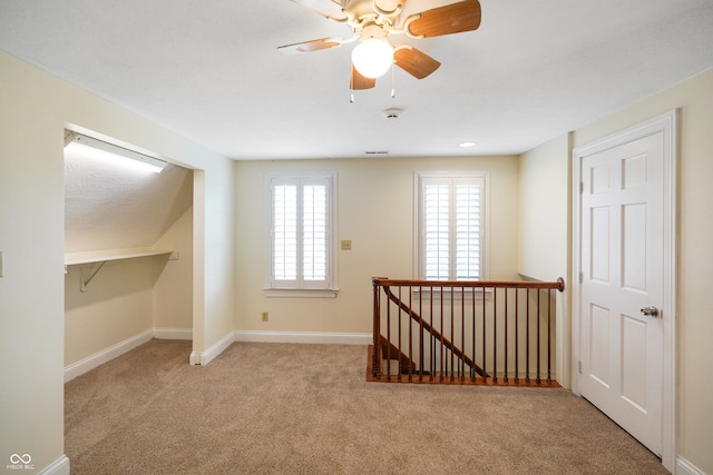 bonus room featuring ceiling fan and light colored carpet