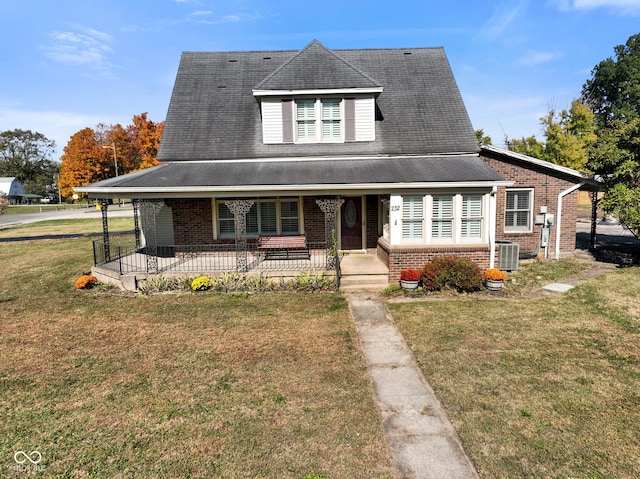 farmhouse with central AC unit, covered porch, and a front lawn