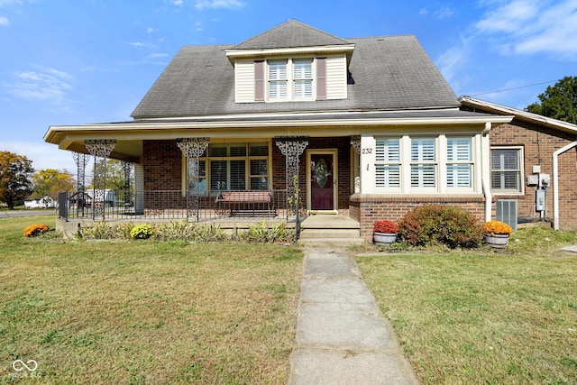 view of front facade featuring covered porch, a front yard, and central AC