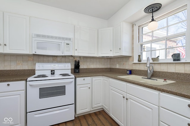 kitchen with white appliances, dark countertops, backsplash, and a sink