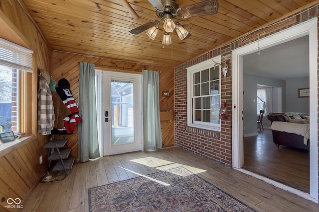 unfurnished sunroom featuring wood ceiling and ceiling fan