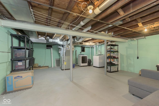 unfinished basement featuring heating unit and separate washer and dryer