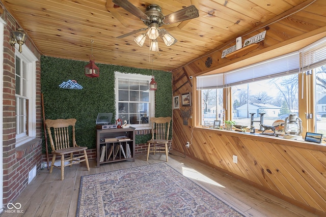 sunroom with a ceiling fan and wood ceiling