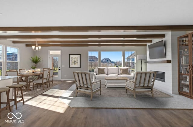 living room with beamed ceiling, dark wood-style flooring, a fireplace, and a healthy amount of sunlight