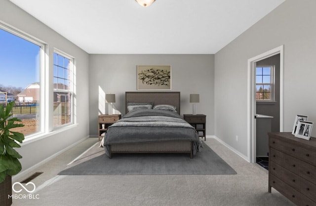 bedroom with light carpet, visible vents, and baseboards