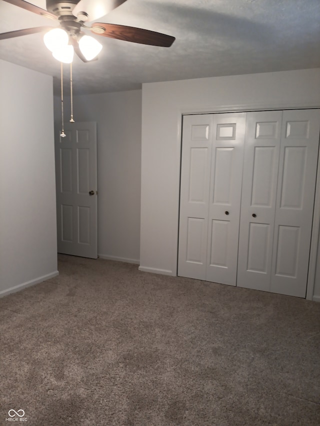 unfurnished bedroom with carpet, ceiling fan, and a closet