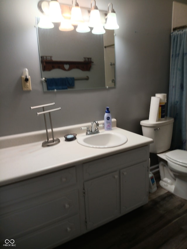 bathroom with hardwood / wood-style floors, vanity, and toilet