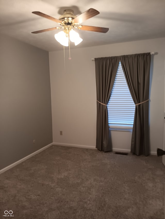 empty room featuring dark colored carpet and ceiling fan