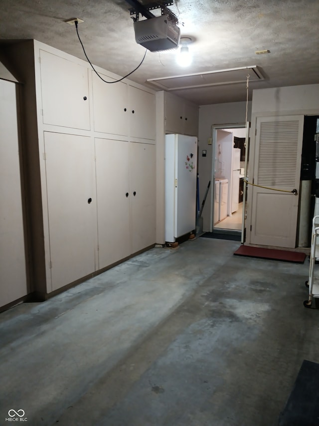 garage featuring white refrigerator, washer / dryer, and a garage door opener